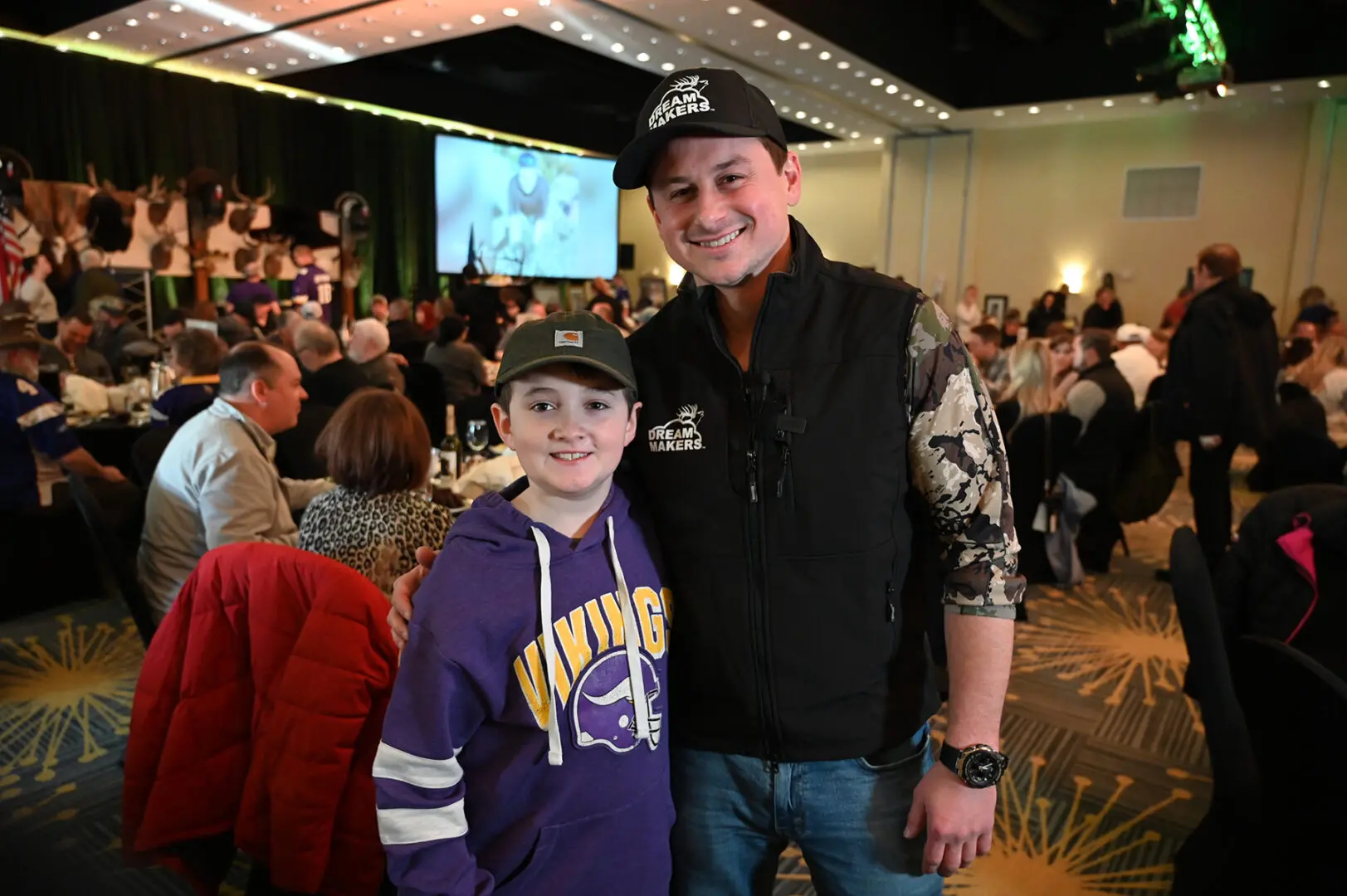 A man and boy posing for the camera at an event.