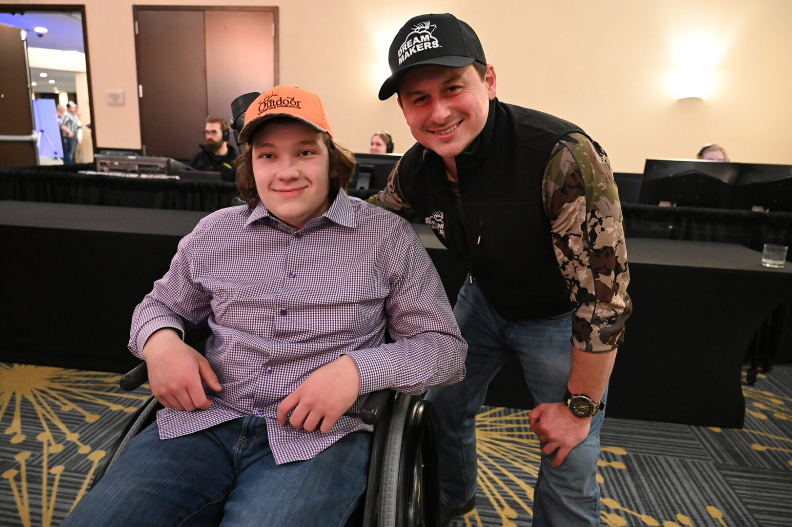 A man and boy in a wheelchair posing for the camera.