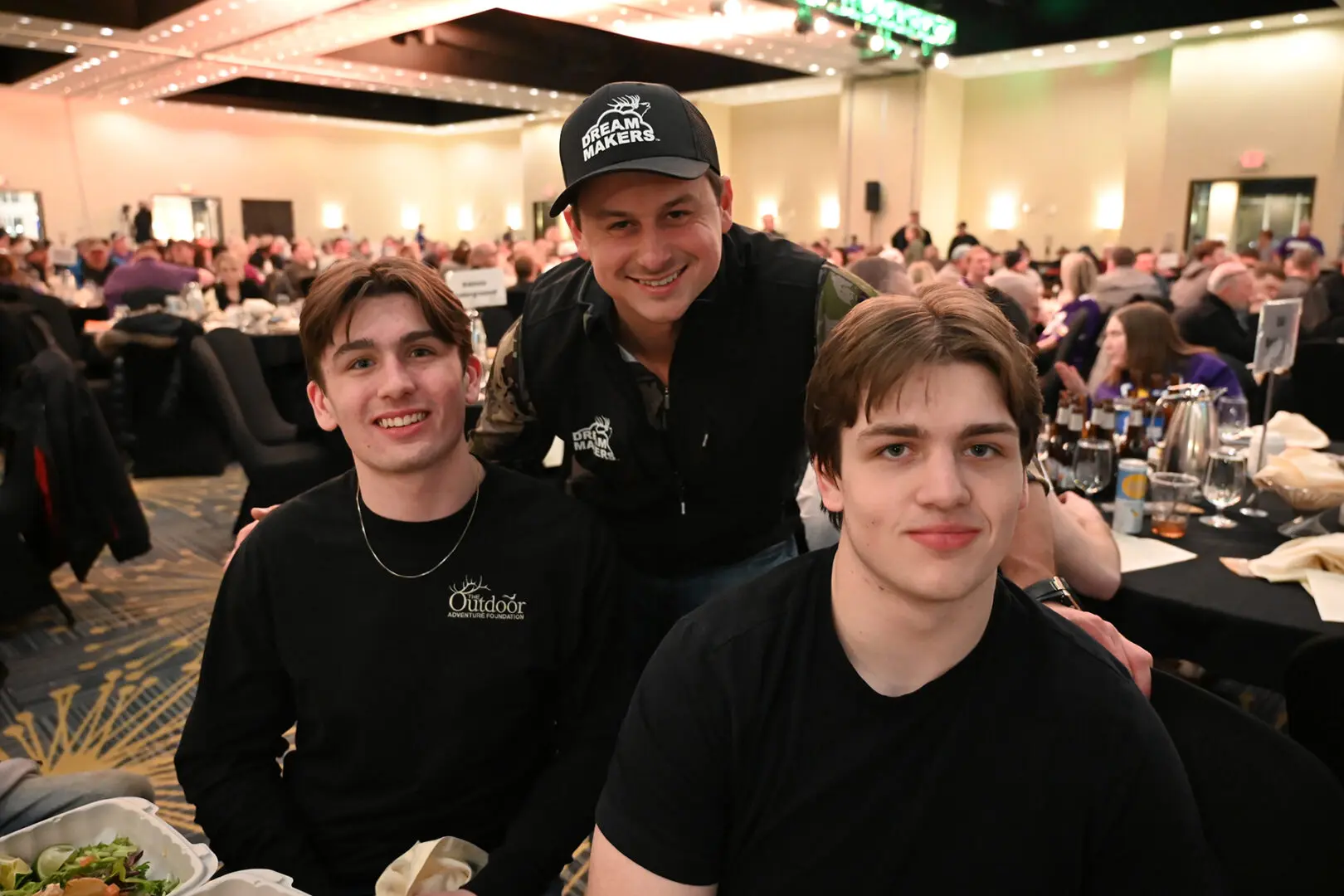 Three men posing for a picture at an event.
