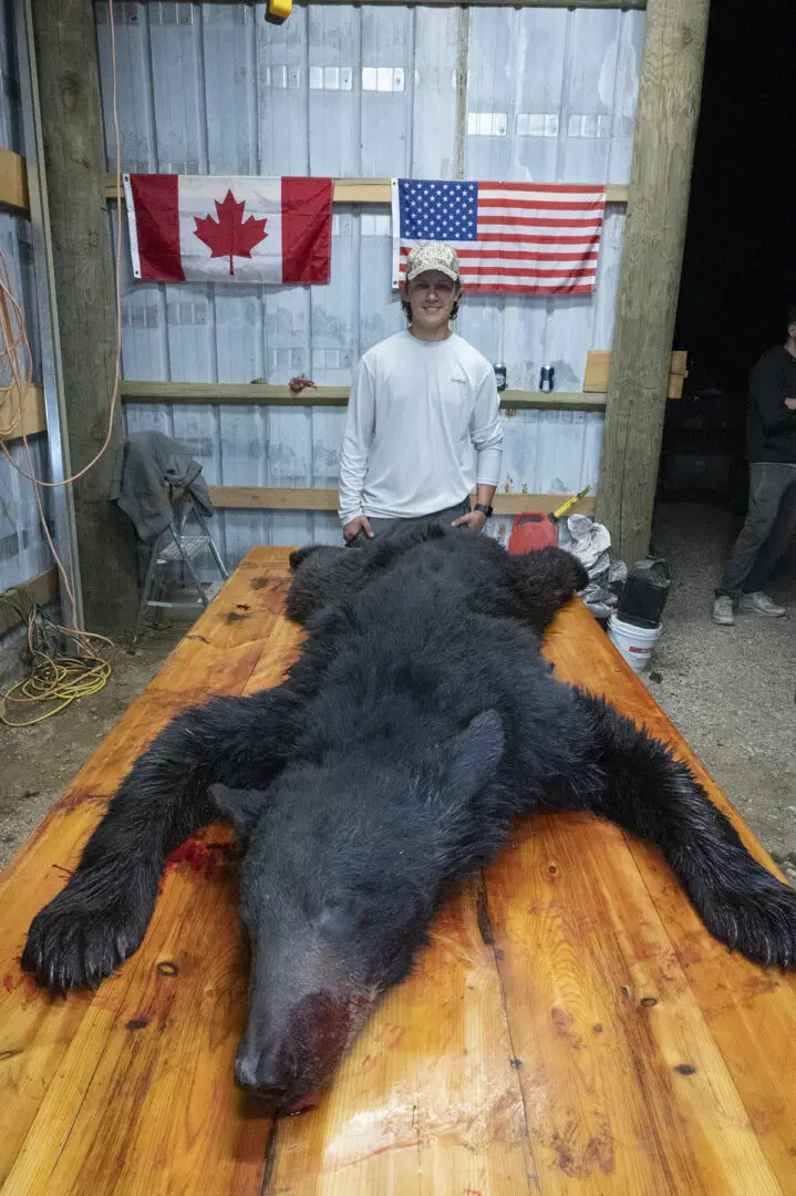 A man standing next to a bear on top of a table.