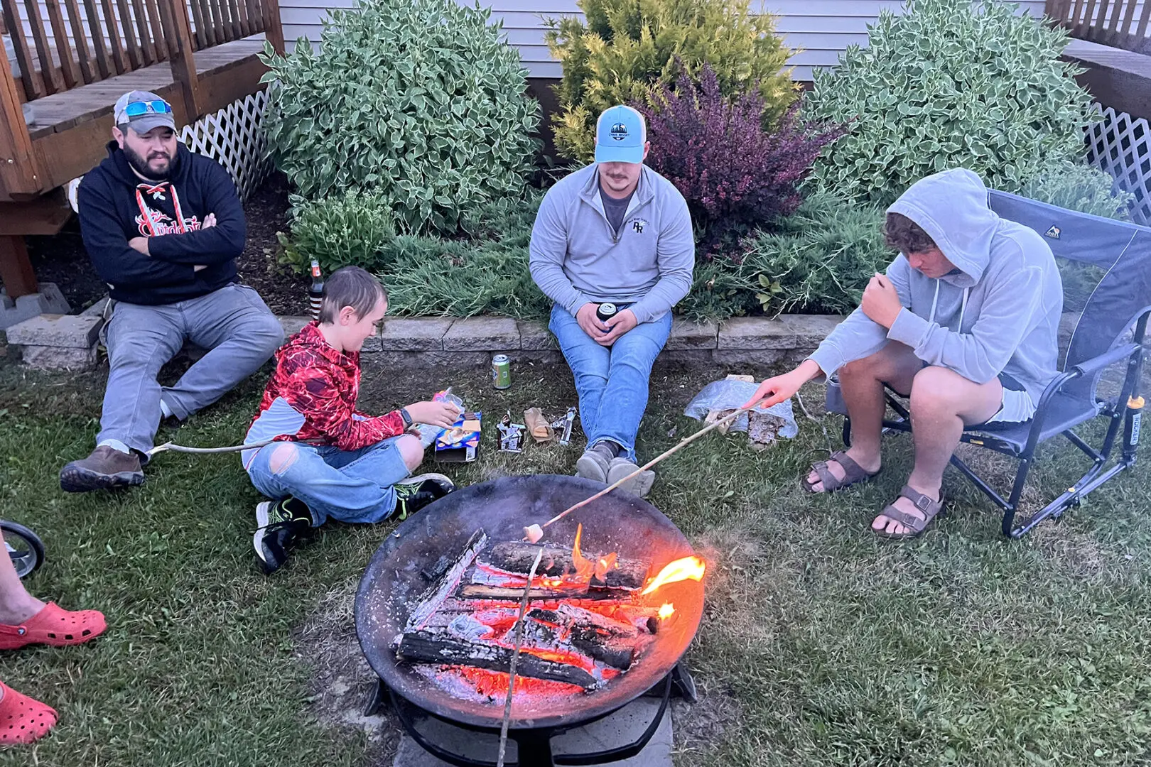 A group of people sitting around a fire pit.