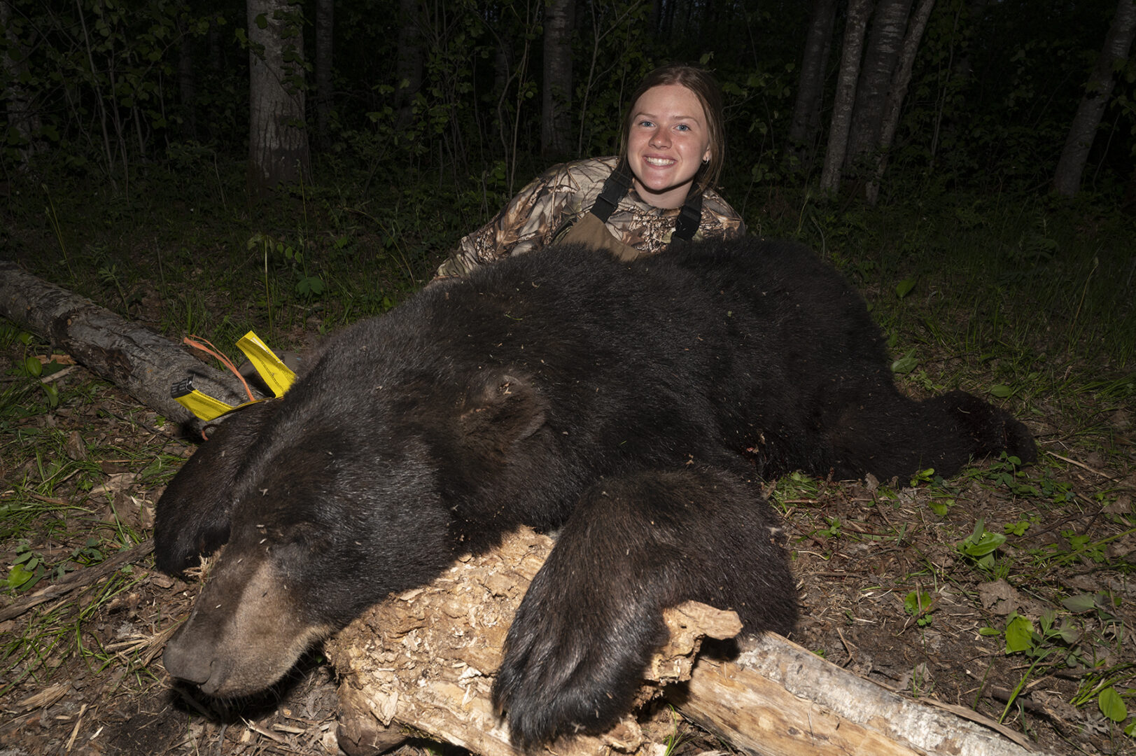 A woman is sitting next to a bear