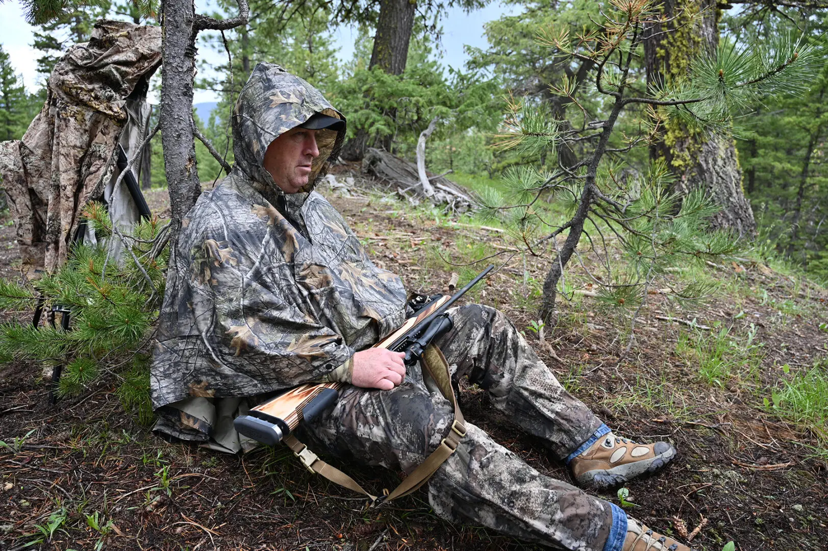 A man in camouflage sitting on the ground.