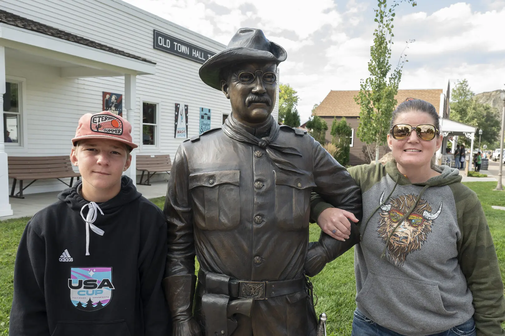 A statue of an officer in uniform with two people.