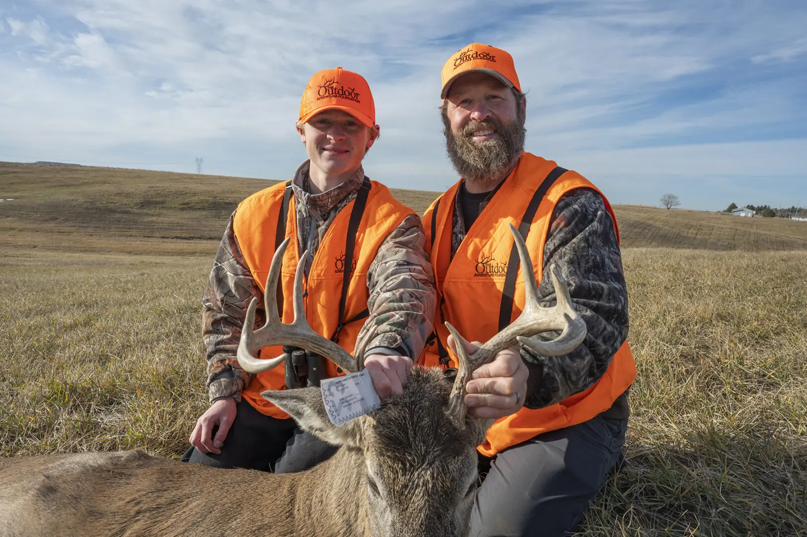 Dash Ohlsen holds his white-tailed buck with his father Taner Olsen